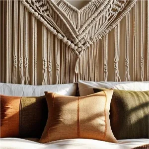 A neutral-toned macramé hanging above a bed with boho pillows and throws.